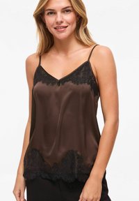 Camisole en satin marron avec bordure en dentelle noire le long de l'encolure et de l'ourlet, dotée de fines bretelles ajustables et d'une texture lisse.