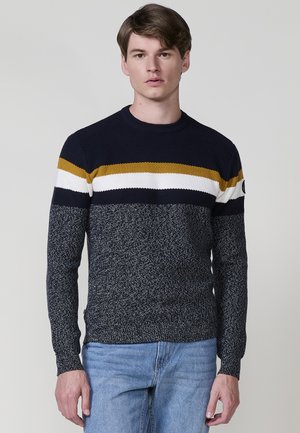 Marineblauer Strickpullover mit horizontalen Streifen in Senfgelb, Weiß und Schwarz. Der Stoff ist gerippt; taillierte Passform mit Rundhalsausschnitt.