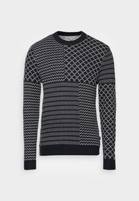 Pull bleu marine présentant des motifs géométriques mélangés en blanc, avec un col rond, des manches longues, des poignets et un ourlet côtelés. Tricot doux et texturé.