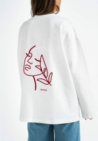 Witte sweatshirt met lange mouwen, versierd met een bordeauxrood geborduurd gezicht en een bladvormige acccent op de achterkant. Ontspannen pasvorm, gemaakt van katoen.
