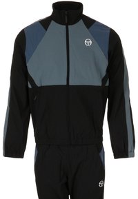 Giacca sportiva nera e grigia con zip frontale, blocchi di colore geometrici, polsini elasticizzati e logo sul petto e sulla vita.