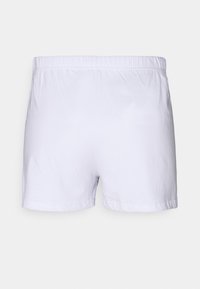 Witte katoenen shorts met een elastische tailleband, met een eenvoudig ontwerp en zonder extra patronen of versieringen.