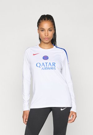 Langermet hvit sportsskjorte med blå og røde aksenter. Har "QATAR AIRWAYS" logo og sirkulært teamemblem på brystet.