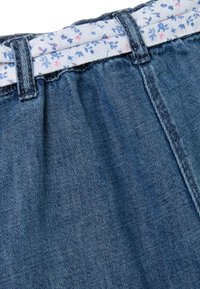 Shorts de denim con una cinturilla de tela con estampado floral. El denim presenta un tono azul clásico y una superficie suave y texturizada.