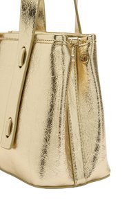 Złota metaliczna torebka o fakturowanej powierzchni, wyposażona w zamek błyskawiczny, dwa paski oraz usztywniony kształt. Charakterystyczna ze względu na błyszczącą powierzchnię.