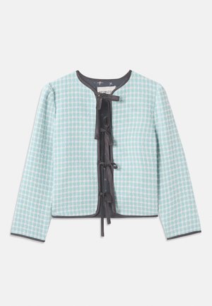 Világoskék, kockás anyagú zakó, kerek nyakú, hosszú ujjú, fekete díszítéssel és középen masni részlet a záródáshoz.