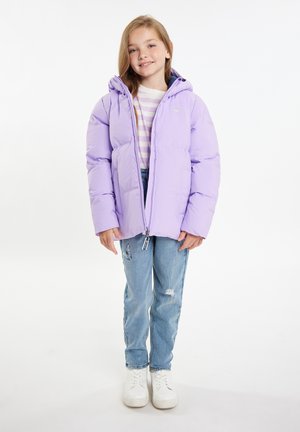 Lila pufferjack met capuchon, ritssluiting en een zachte textuur; gedragen over een gestreept shirt en gecombineerd met lichtblauwe jeans en witte sneakers.