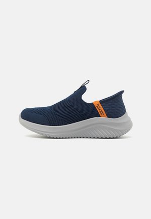 Marineblaue Slip-On-Sneaker mit atmungsaktivem Strick-Obermaterial, Zuglasche an der Zunge, strukturiertem Absatz, orangefarbenem Label und dicker weißer, geriffelter Sohle.