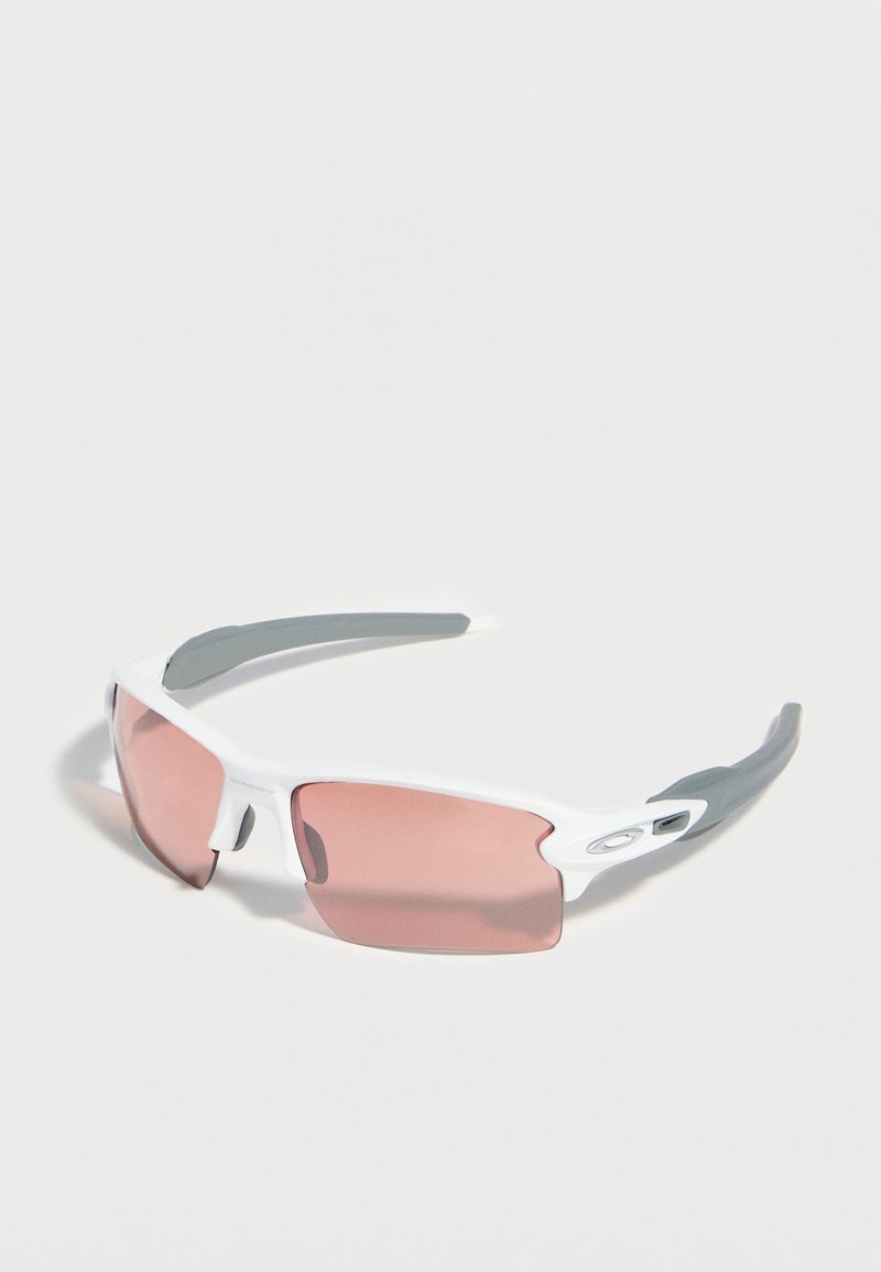 Λευκά αθλητικά γυαλιά ηλίου με ροζ φακούς και γκρι λαστιχένια άκρα στα μπράτσα, πάνω σε απλό φωτεινό φόντο.