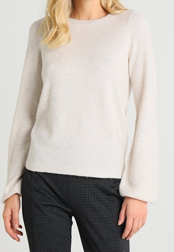 Lys beige, langærmet sweater lavet af blødt materiale med en afslappet pasform. Rund halsudskæring og let pufede ærmer. Parret med ternede bukser.
