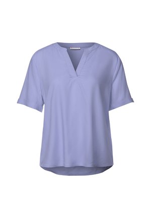 Blusa lilla a maniche corte con scollatura a V, caratterizzata da una vestibilità ampia e una texture di tessuto liscia. L'orlo è leggermente curvo sul retro.