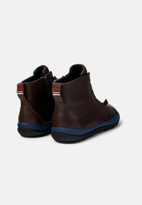 Stivaletti in pelle marrone con suola in gomma blu, dotati di un tassello posteriore con il marchio 'CAMPER' e 'GORE-TEX' e un design parzialmente chiuso.