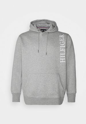 Jasnoszara bluza z kapturem z przednią kieszenią typu kangur i białym pionowym napisem "HILFIGER" na prawym ramieniu.