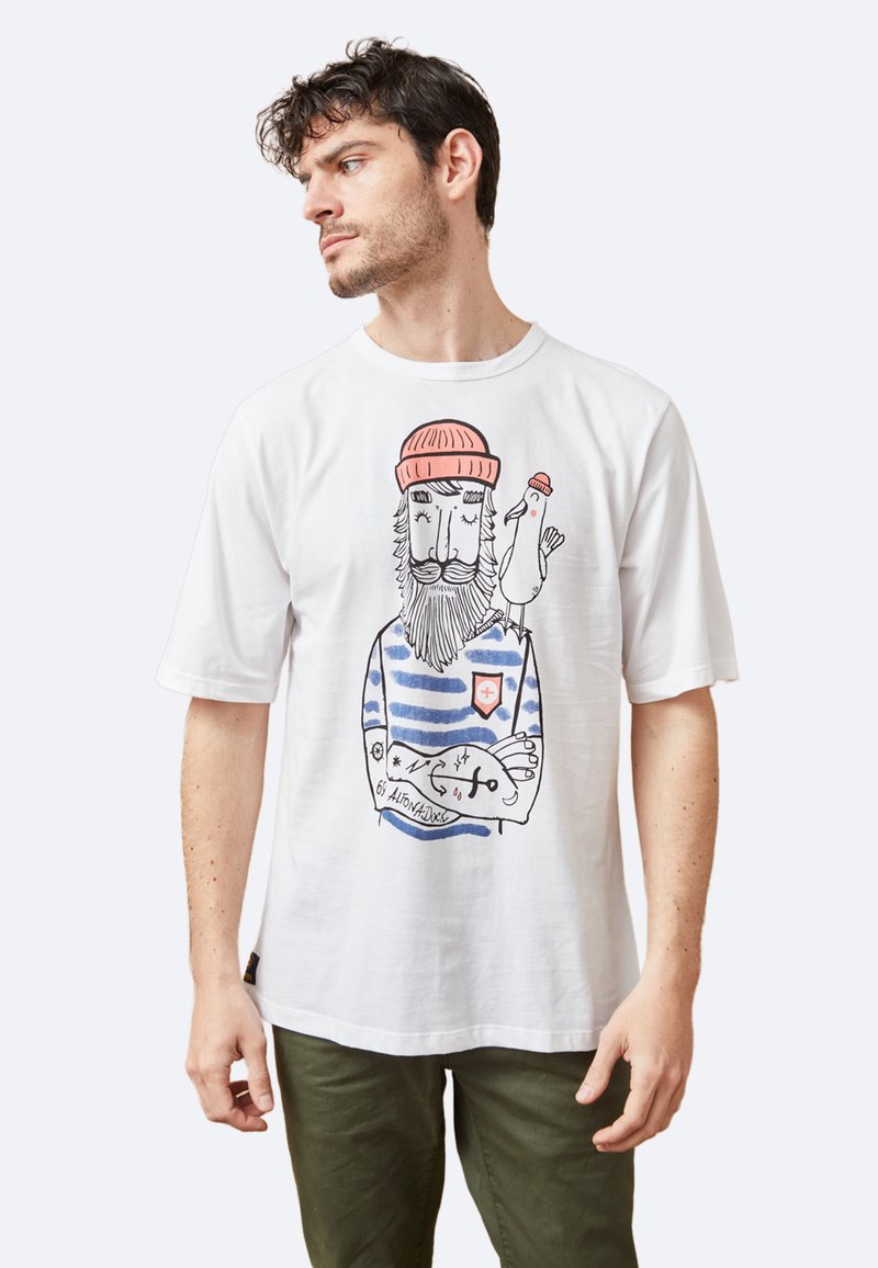 Camiseta de algodón blanco con un diseño gráfico a rayas azules de un hombre barbudo con un pájaro, destacando ilustraciones divertidas y colores llamativos.