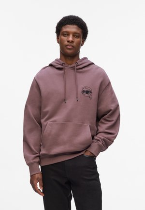 Hooded sweatshirt v tihem mauvem z sprednjim žepom in majhno grafiko lika v sončnih očalih. Ima vrvice za zategovanje in rebraste manšete.