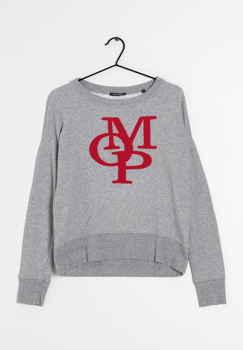 Sweat-shirt gris à manches longues avec des lettres rouges qui se chevauchent "MGP" sur le devant, accroché à un cintre noir sur un fond blanc.