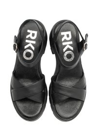 Crne sandale s ukriženim trakama, s podesivim kopčanjem oko gležnja, teksturiranim uloškom i otisnutim "RKO" logom na ulošku.