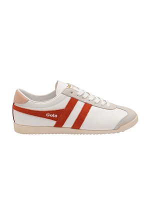 Zapatilla blanca con rayas de ante naranja, puntera de ante gris y talón acolchado. Presenta cordones trenzados y la marca "Gola" en dorado. Suela de goma.