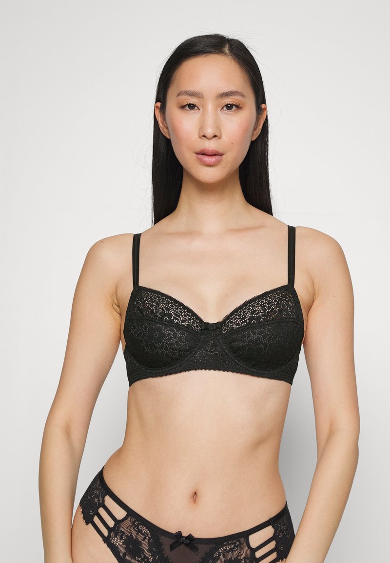 Schwarzer Spitzen-BH mit Unterdraht, dekoriert mit floralem Muster, verstellbaren Trägern und einer Schleifenakzent in der Mitte. Weicher, strukturiertes Material.