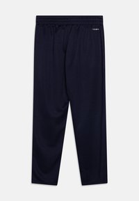 Tummansiniset urheiluhousut, jotka on valmistettu hengittävästä kankaasta. Niissä on joustava vyötärö ja kapenevat lahkeet. Siisti muotoilu, jossa on minimaalinen yksityiskohtaisuus.