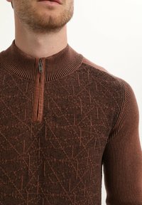 Brązowy sweter dzianinowy z wysokim kołnierzem i zamkiem błyskawicznym na 1/4. Posiada teksturowany geometryczny wzór oraz prążkowane akcenty na kołnierzu i rękawach.