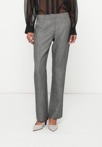 Γκρι παντελόνι από μάλλινο μείγμα με λεπτό καρό σχέδιο, κανονική γραμμή και μέση μεσαίου ύψους. Συνδυασμένο με μπεζ γόβες με μυτερή μύτη.