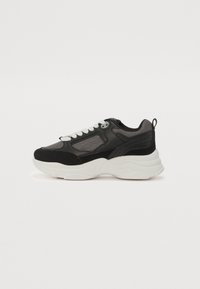 Schwarzer und grauer Sportschuh mit Mesh-Einsätzen, abgerundeter Zehenpartie, weißer Zwischensohle und kontrastierenden strukturierten Akzenten. Verfügt über Schnürsenkel und eine Schlaufe zum Anziehen.