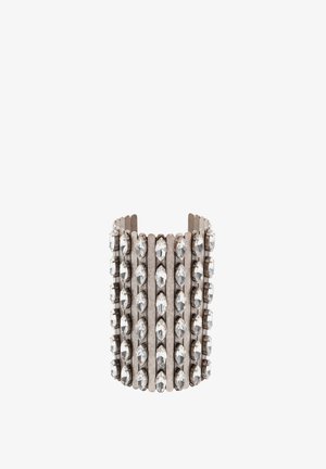 Metalowa bransoleta mankietowa z pionowymi rzędami przezroczystych cyrkonii. Wzór obejmuje teksturowaną srebrną powierzchnię o szerokim, otwartym kształcie.