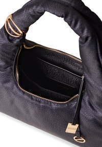 Black fabric handbag with a soft, textured exterior, featuring a zip closure, gold hardware accents, and an inner pocket with logo detail.