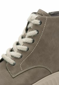 Grauer Leder-High-Top-Sneaker mit beigen Filzsenkeln, Metallösen und kontrastierenden Nähten. Abgerundete Zehenpartie und strukturierte Gummisohle.