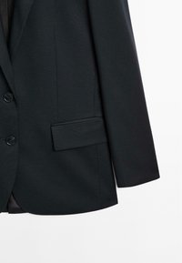 Svart skräddarsydd blazer med tvåknapprad, fickor med klaff, strukturerade axlar och slät tygkvalitet.