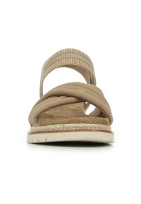 Sanda en tejido beige con diseño cruzado, correa elástica, plantilla suave y suela de goma blanca con un detalle de yute alrededor de la base.