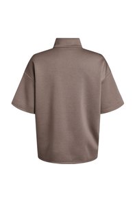Ylisuuressa lyhythihaisessa polo-paidassa on hillitty ruskea sävy, siinä on pystykaulus ja sileä, pehmeä kangas.