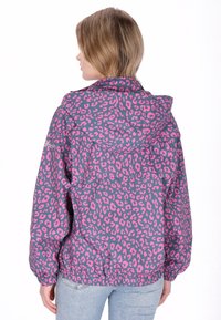 Mikina s kapucí s růžovým a šedým leopardím potiskem. Má elastické manžety a šňůrkový okraj, vyrobená z lehké tkaniny.