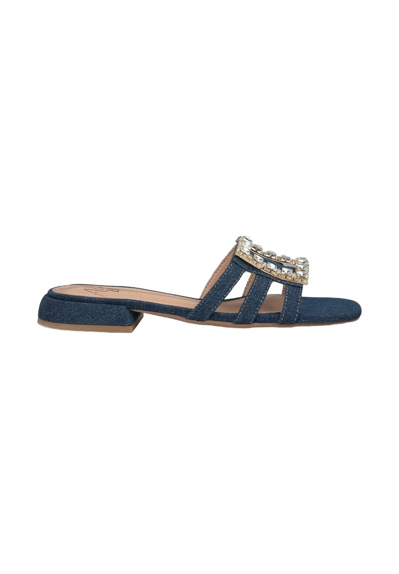 Denim slide sandals with a low block heel, featuring three straps and a decorative rhinestone accent at the front.