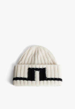Knit beanie in cream with a black abstract pattern. Features a ribbed texture and cuffed design, providing warmth and coverage.