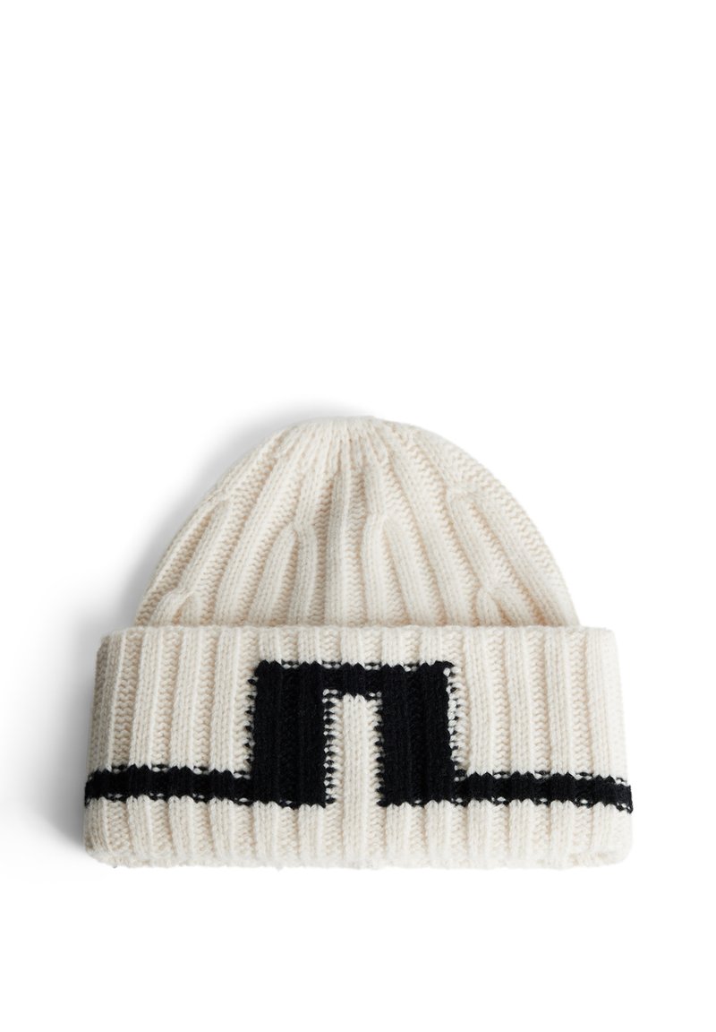 Kreemivärvi kudumisbeanie musta abstraktse mustriga. Omab soonikkoest ja ääre kujundust, pakkudes soojust ja katvust.