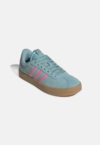 Lichtblauwe suède sneaker met drie roze strepen, ronde neus en een zool van gum rubber. Veters in dezelfde kleur als de schoen, minimalistisch design.