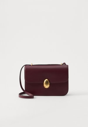 Burgundská kožená crossbody taška s hladkým povrchom, oválnym zlatým zapínaním a nastaviteľným popruhom, s jednoduchým obdĺžnikovým tvarom.