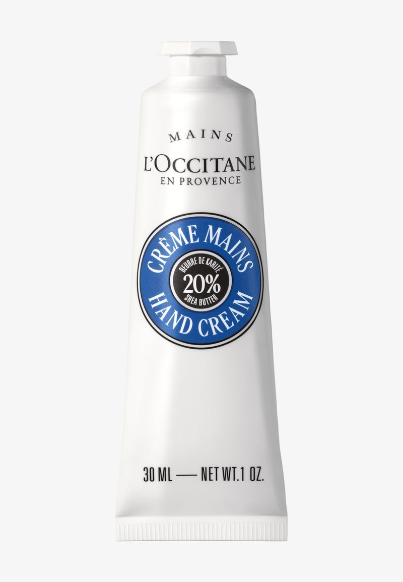 L'Occitane håndcremetube med 20% sheasmør, blå cirkulær etiket, 30 ml (1 oz) størrelse, hvid emballage og sort tekst.