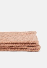 Cobertor com textura de waffle em suave cor pêssego, dobrado com uma textura ligeiramente felpuda, apresentando um padrão uniforme e bordas bem acabadas.