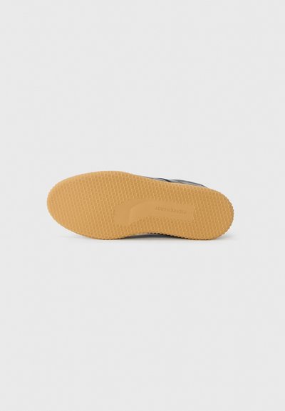 Suola nera da sneaker con un design in gomma gommata testurizzata. Caratterizzata da un logo impresso sul lato e da un motivo di indentazioni quadrate.