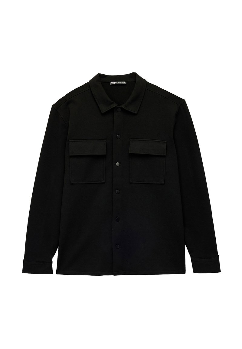 Camisa negra de botones, hecha de una tela suave con cuello puntiagudo, que cuenta con dos bolsillos en el pecho y un dobladillo recto. Sin patrones ni acentos visibles.