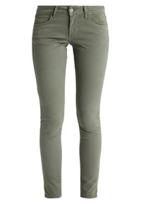 Jeans skinny verde oliva con una textura suave, diseño de cinco bolsillos, cierre frontal con cremallera y botón metálico. Presenta sutiles acentos de costura.