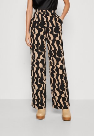 Weite Hose mit einem schwarz-beigen abstrakten Muster, aus glattem Stoff gefertigt, mit hoher Taille und Seitentaschen.