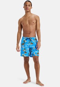 Modré plážové šortky s tropickým vzorom ostrova, elastický pás s šnúrkou. Tkanina sa zdá byť ľahká s hladkým povrchom.