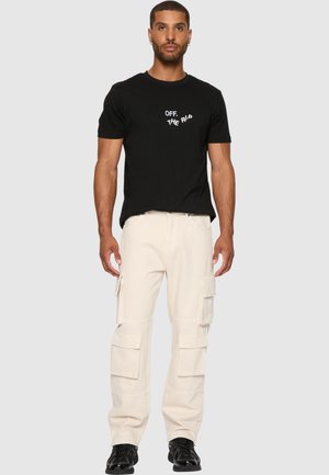 Black cotton t-shirt with white text "OFF. THE RIBS" on the front, paired with beige cargo pants featuring multiple pockets and a loose fit.
