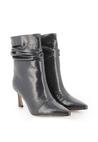 Botas de tobillo de cuero negro con un diseño arrugado, puntera afilada y tacón de aguja. Textura suave con un mínimo de detalles y un suave brillo.