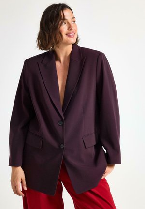 Blazer oversize bordeaux con revers, chiusura a un bottone e due tasche anteriori, realizzato in un tessuto testurizzato.