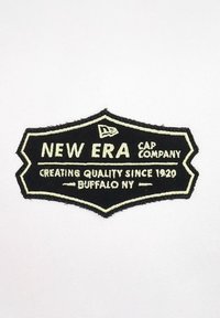 Schwarzer bestickter Patch mit dem Schriftzug "NEW ERA CAP COMPANY" und "CREATING QUALITY SINCE 1920" sowie einem weißen Rand und einem Logo.